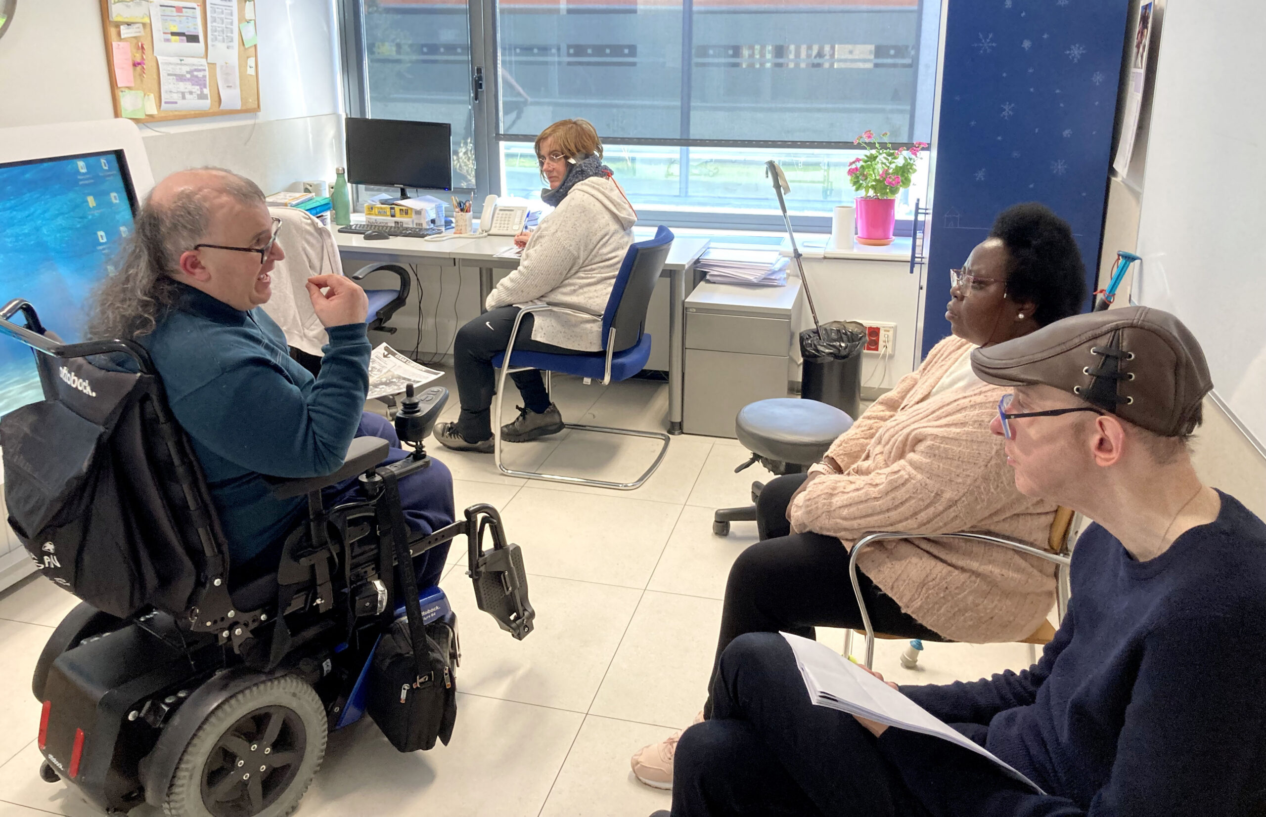 En la imagen aparece, a la derecha, Joshe Etxenike, el autor del texto y profesor de euskera, en silla de ruedas. A su alrededor dos alumnas y un alumno, todos ellos usuarios de Adacen