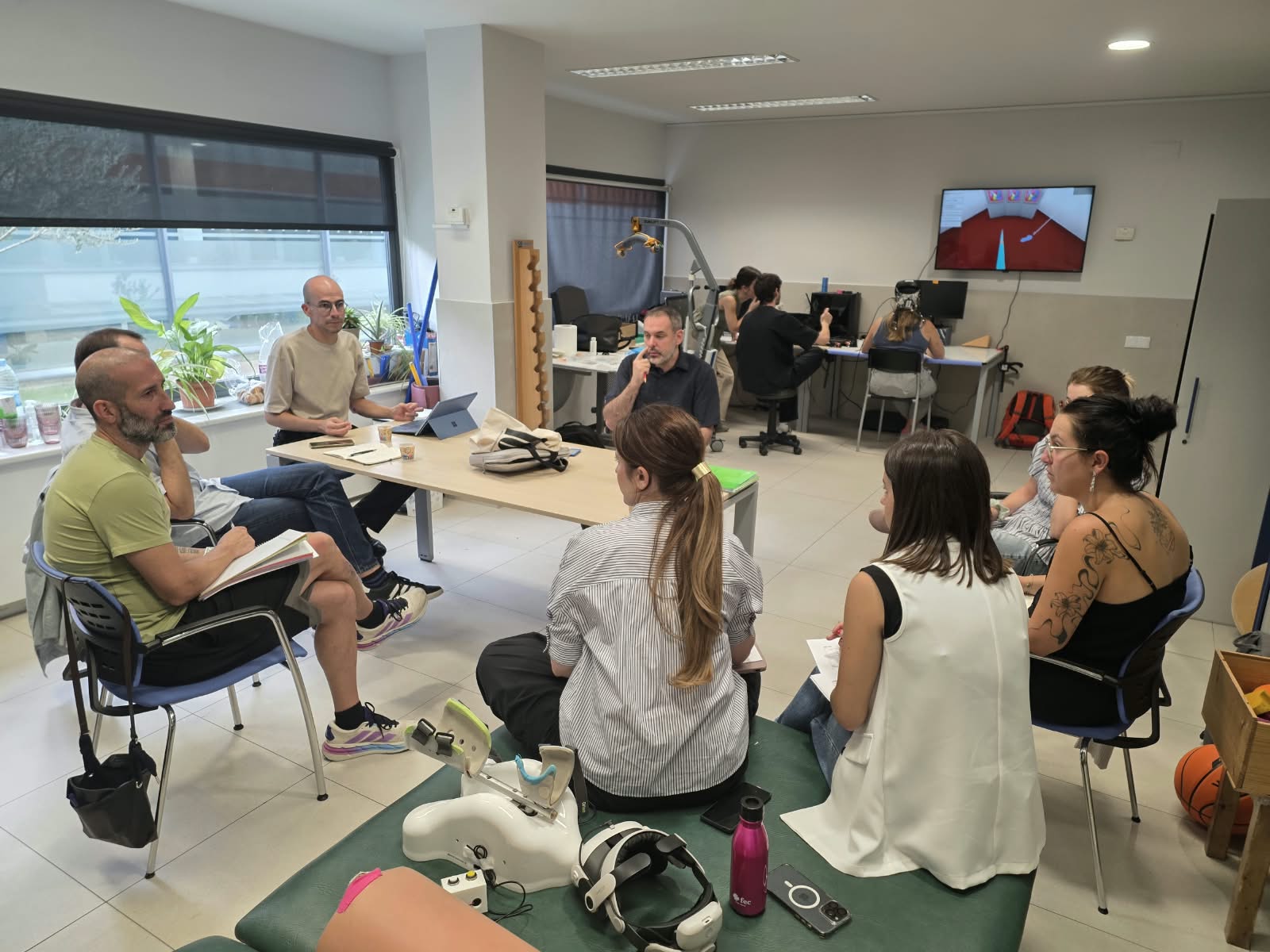 En la foto se ve a un grupo de profesionales de Adacen y del resto de las entidades mencionadas en la noticia participando en una reunión. Se encuentran en círculo alrededor de una mesa
